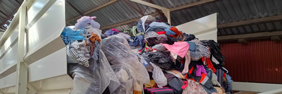 Store mængder tekstilaffald bliver afleveret hos et modtageranlæg.
